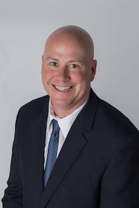 Mark Wild pictured smiling on a white background